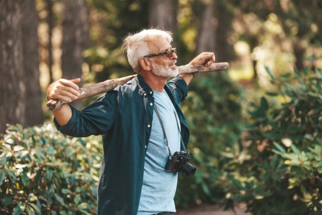 A,Mature,Bearded,Grandfather,Holds,A,Stick,On,His,Shoulders.